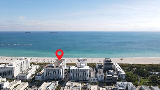 birds eye view of property featuring a water view and a beach view