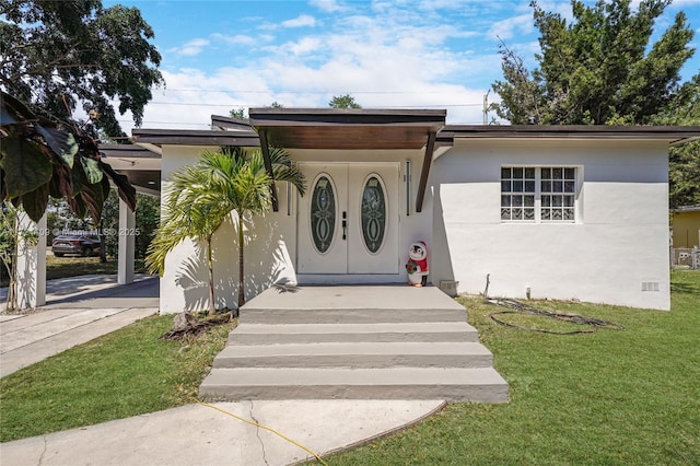 571 Raven Ave, Miami Springs, FL 33166 - view of front of home with a front yard, driveway, and stucco siding