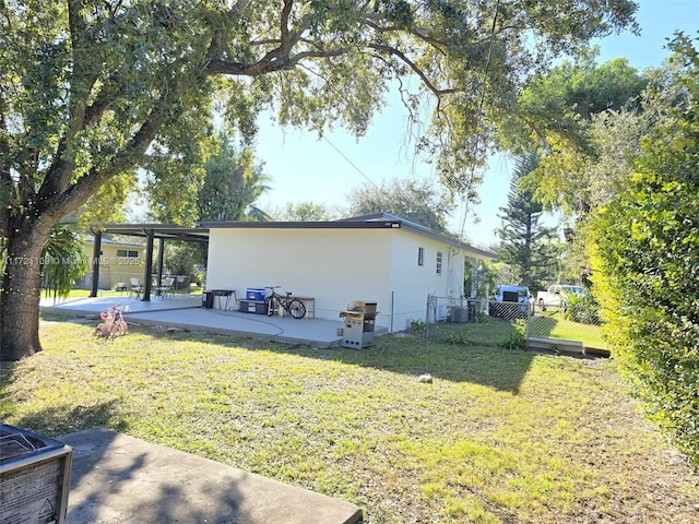 view of side of property featuring a patio and a yard