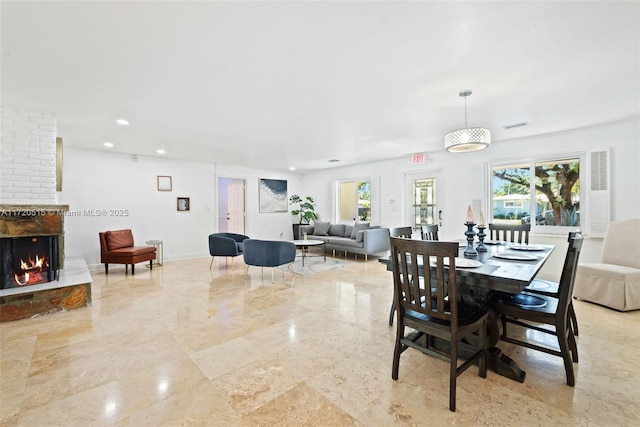 dining space featuring a large fireplace