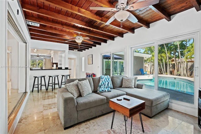 living room with ceiling fan, beamed ceiling, and wooden ceiling