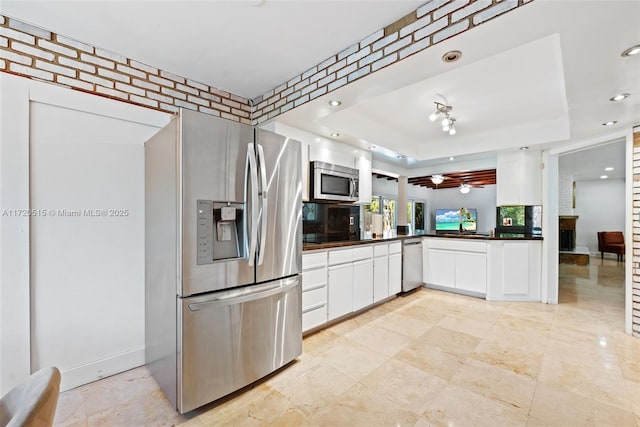 kitchen with white cabinets, a raised ceiling, and stainless steel appliances