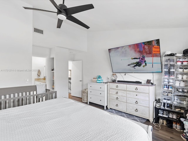 bedroom featuring connected bathroom, ceiling fan, dark hardwood / wood-style flooring, and vaulted ceiling