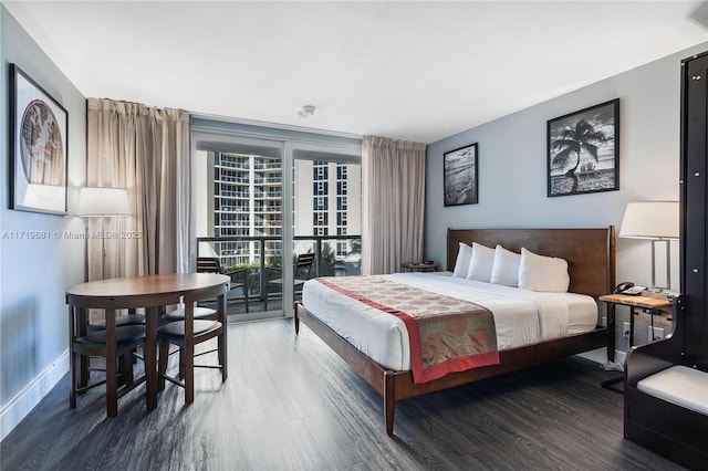 bedroom with expansive windows, access to exterior, and dark wood-type flooring