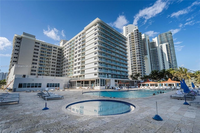 view of pool featuring a community hot tub and a patio