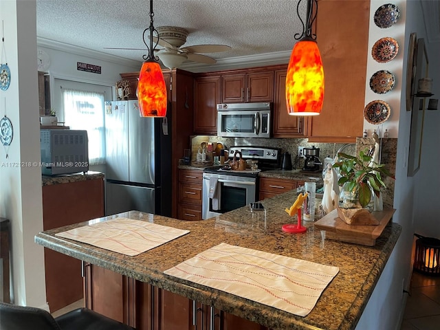 kitchen featuring kitchen peninsula, pendant lighting, stainless steel appliances, and ceiling fan