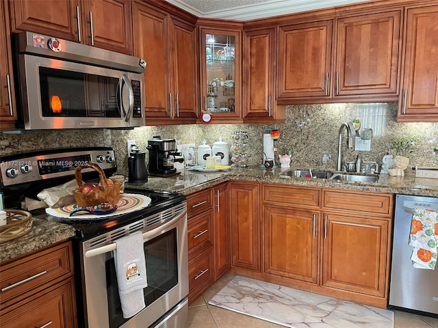 kitchen featuring dark stone countertops, decorative backsplash, sink, and stainless steel appliances