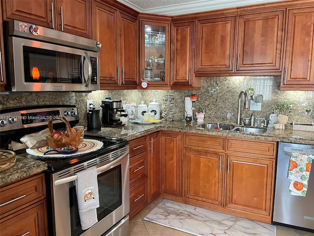 kitchen with sink, decorative backsplash, ornamental molding, stone countertops, and stainless steel appliances