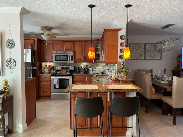 kitchen featuring kitchen peninsula, ornamental molding, stainless steel appliances, ceiling fan, and sink