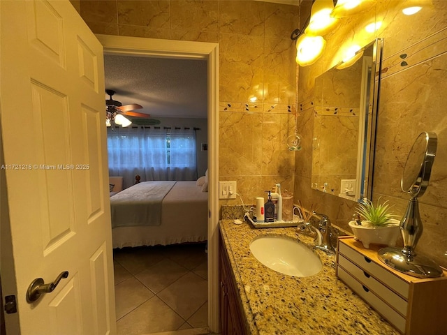 bathroom featuring tile patterned floors, vanity, ceiling fan, and tile walls