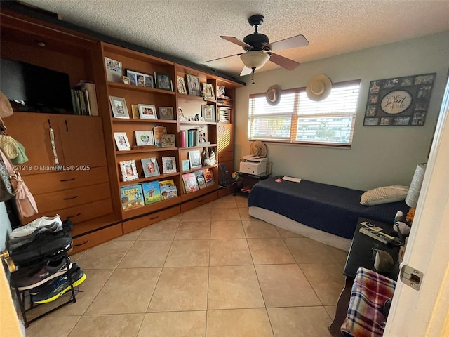 tiled bedroom featuring ceiling fan and a textured ceiling