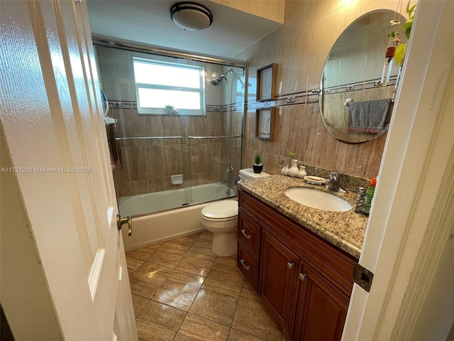 full bathroom with shower / bath combination with glass door, vanity, toilet, and tile patterned flooring