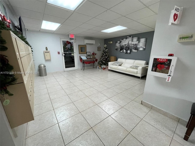 tiled living room with a wall unit AC and a paneled ceiling