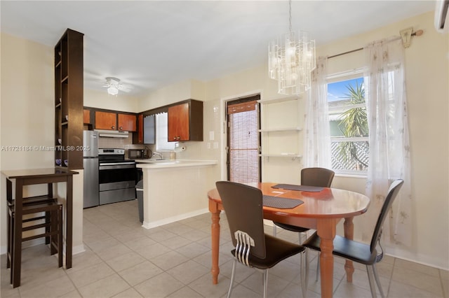 tiled dining space featuring sink, a healthy amount of sunlight, and ceiling fan with notable chandelier