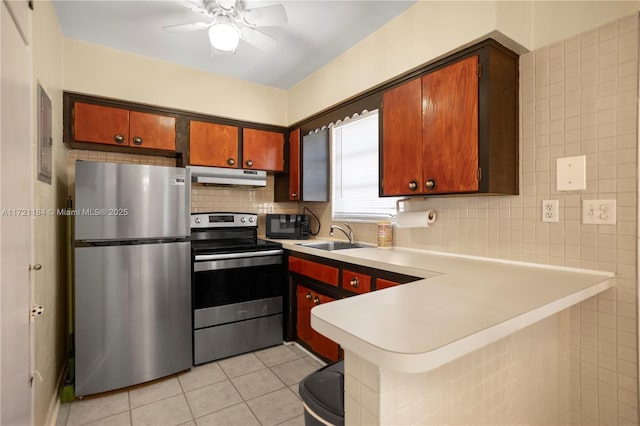 kitchen with ceiling fan, sink, kitchen peninsula, light tile patterned floors, and appliances with stainless steel finishes