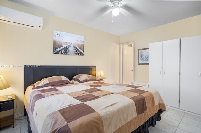 bedroom with a wall unit AC, ceiling fan, a closet, and light tile patterned floors