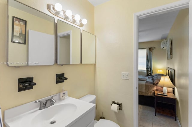 bathroom with tile patterned flooring, vanity, a wall mounted air conditioner, and toilet