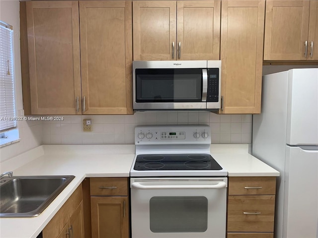 kitchen with decorative backsplash, white appliances, and sink