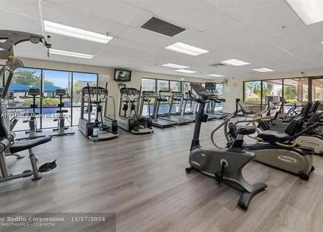 gym with a paneled ceiling and wood-type flooring