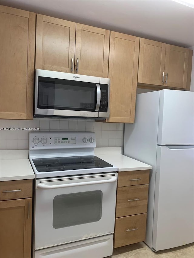 kitchen with decorative backsplash and white appliances