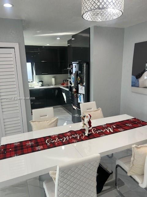 kitchen with a notable chandelier, black refrigerator, and a kitchen bar