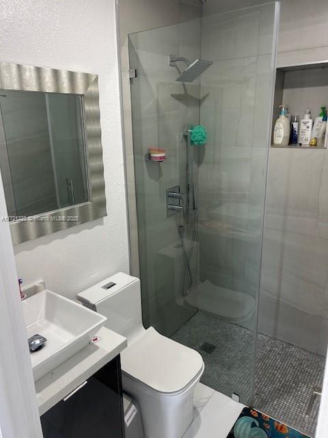 bathroom featuring vanity, toilet, and walk in shower