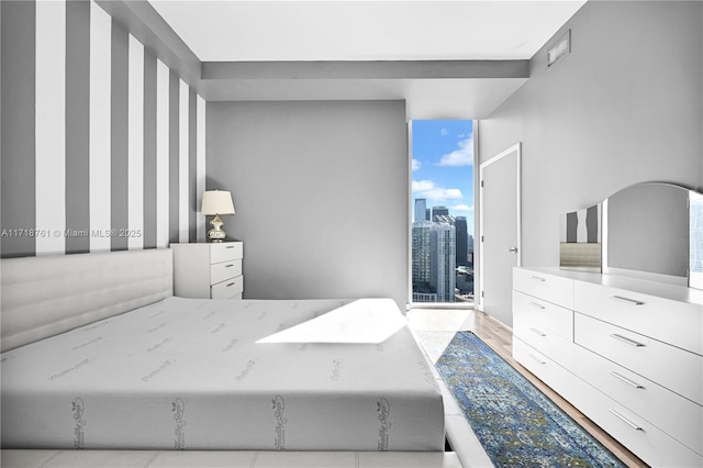 bedroom featuring floor to ceiling windows and light hardwood / wood-style flooring