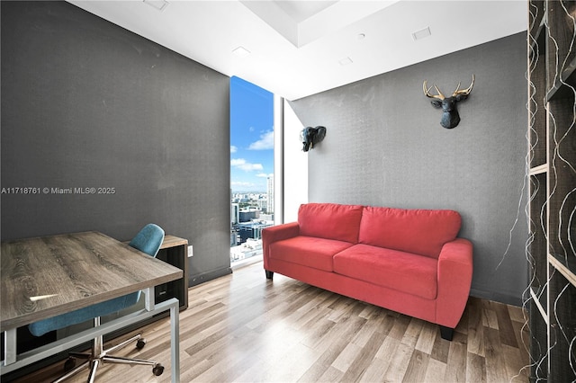 home office featuring expansive windows and hardwood / wood-style flooring