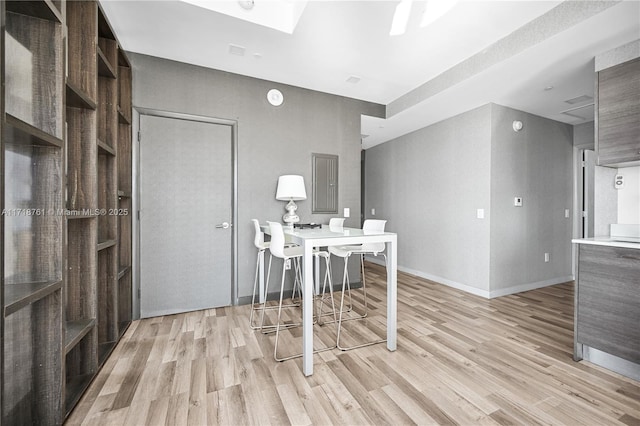 home office featuring electric panel and light hardwood / wood-style floors