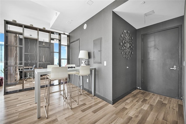 office area with electric panel, hardwood / wood-style floors, and expansive windows