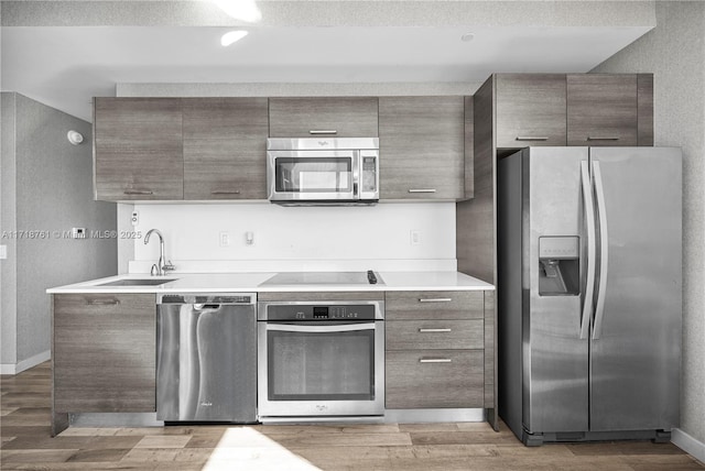 kitchen featuring light hardwood / wood-style floors, sink, and appliances with stainless steel finishes