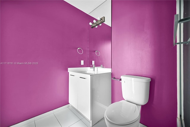 bathroom with toilet, vanity, and tile patterned flooring