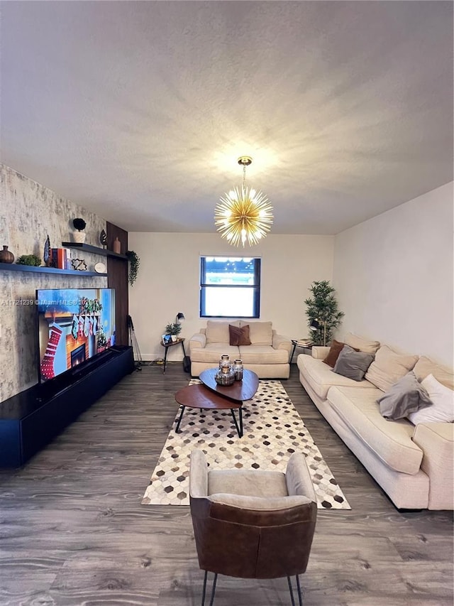 living room with dark wood-type flooring, a notable chandelier, and a textured ceiling