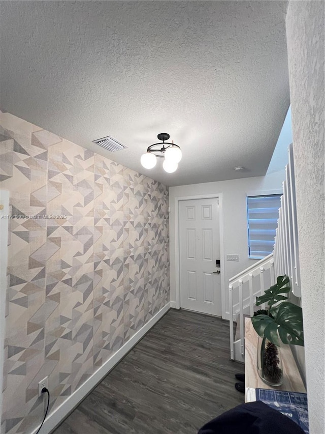 entrance foyer featuring dark wood-type flooring and a textured ceiling