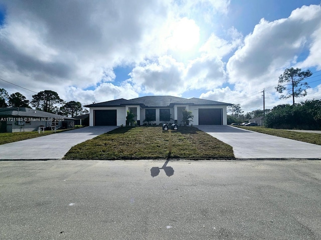 view of front of home with a garage and a front lawn