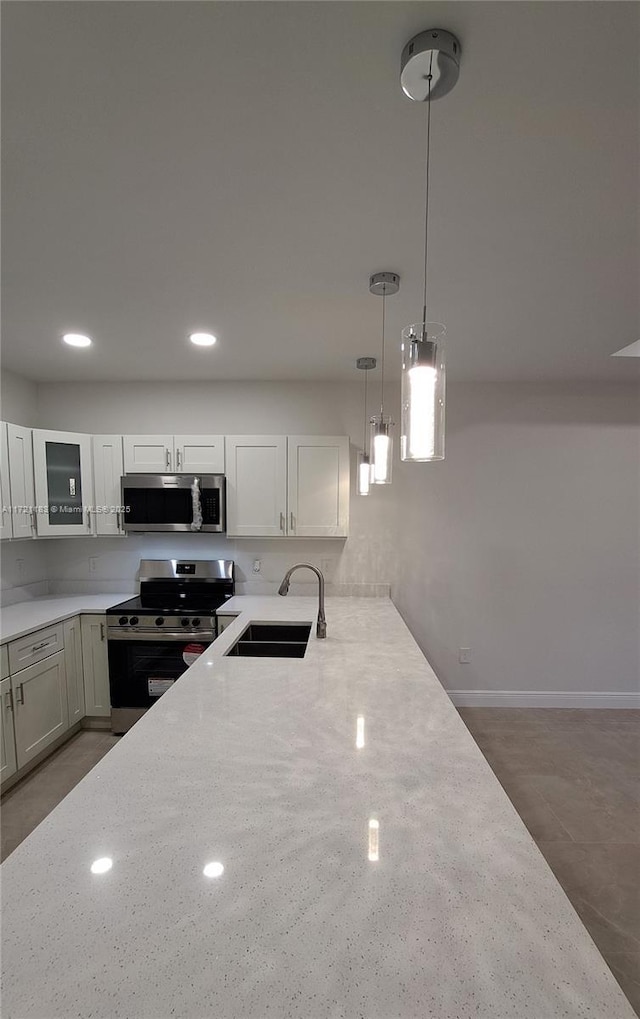 kitchen featuring light stone countertops, sink, white cabinetry, and stainless steel appliances