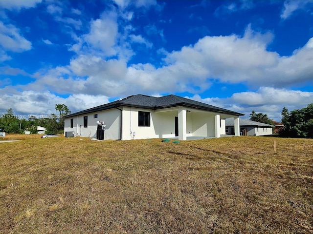 view of side of home featuring cooling unit and a lawn