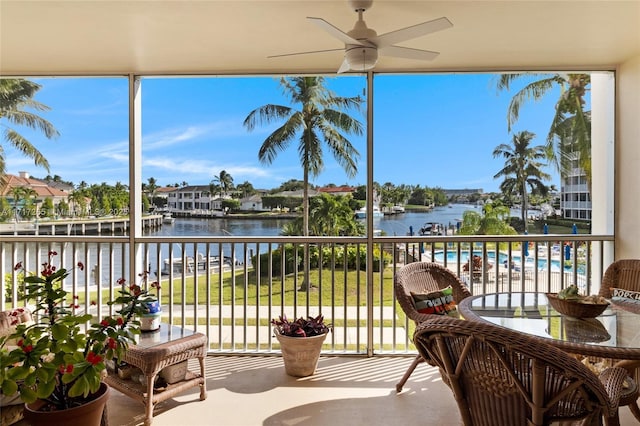 balcony with ceiling fan and a water view