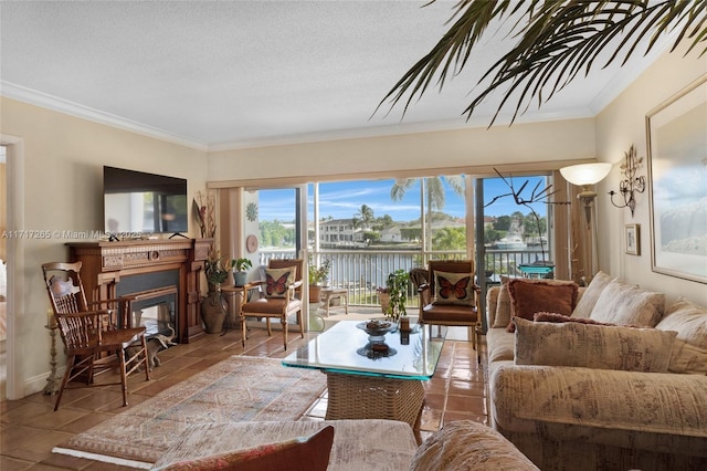 living room featuring tile patterned floors, a glass covered fireplace, ornamental molding, and a textured ceiling
