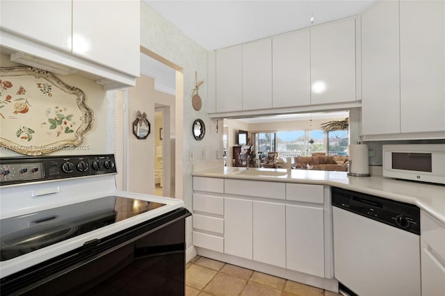 kitchen featuring white cabinetry, light countertops, a sink, and white appliances