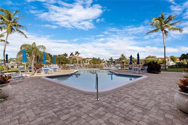 community pool with a patio and fence