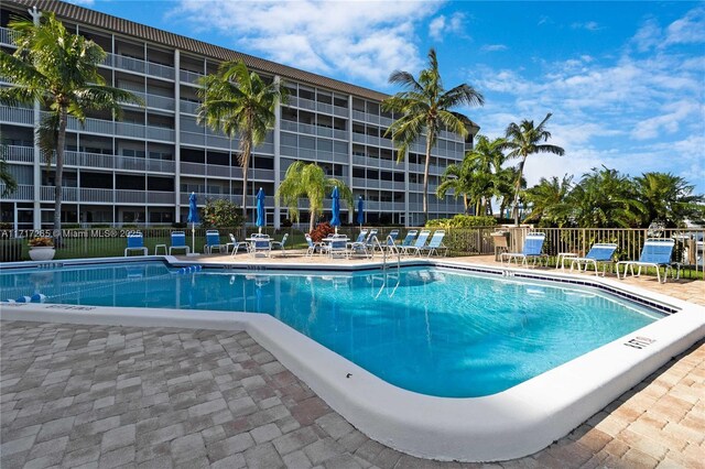 view of swimming pool featuring fence and a patio