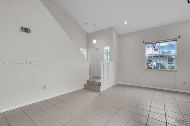 unfurnished living room with light tile patterned floors, vaulted ceiling, and a healthy amount of sunlight