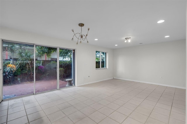 tiled spare room featuring an inviting chandelier