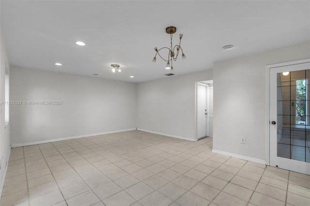 tiled empty room featuring an inviting chandelier