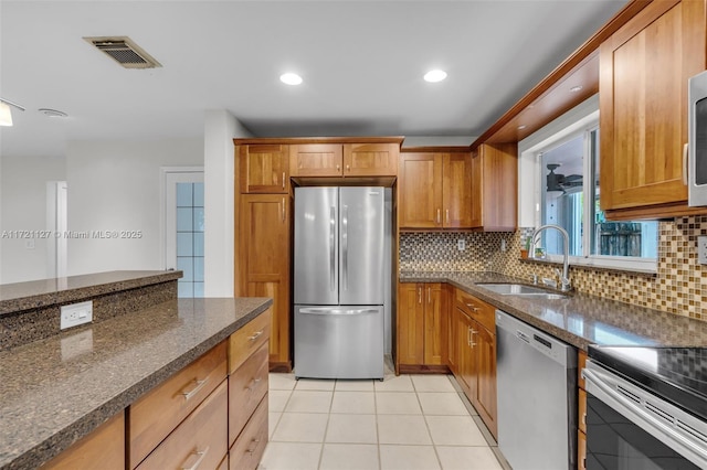 kitchen with light tile patterned floors, stainless steel appliances, sink, and backsplash