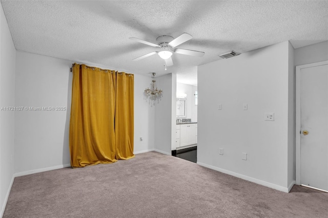 carpeted empty room with ceiling fan and a textured ceiling