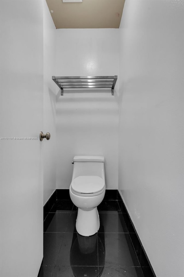 bathroom with toilet and tile patterned flooring