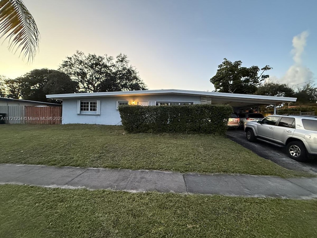 view of front of house with a yard and a carport