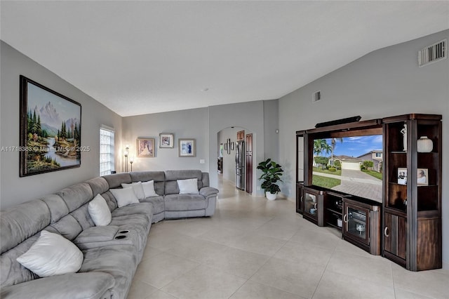 tiled living room featuring vaulted ceiling